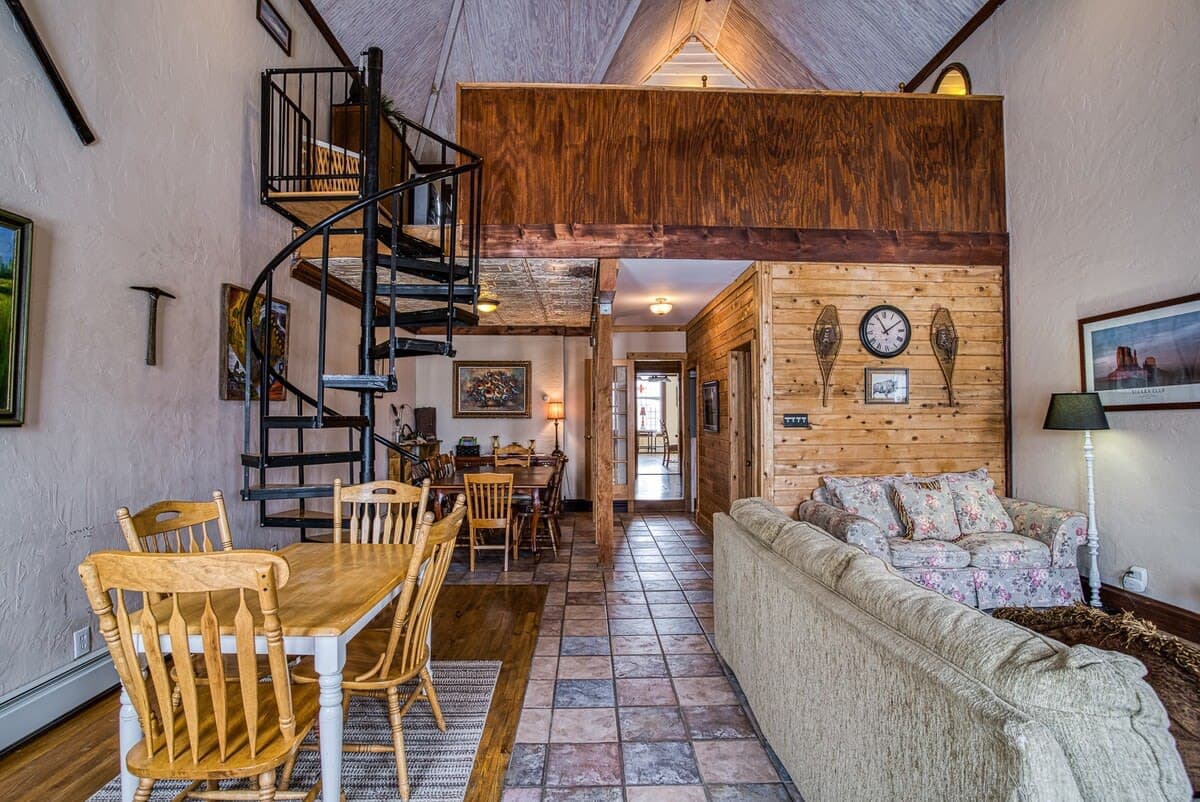 【Living Room】 Gas fireplace + tall Victorian windows — winter and summer both work here.