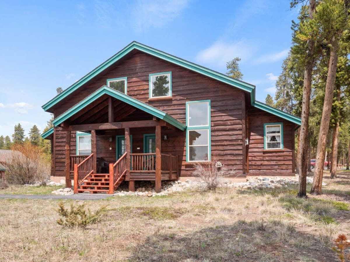 【Exterior】The Southpaw cabin — log-sided, southwestern porch, designated parking right out front.