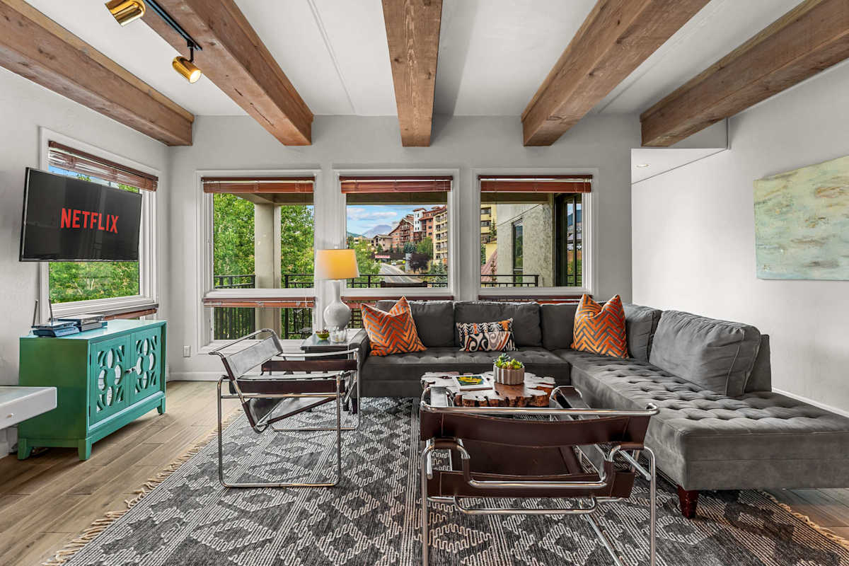 【Living Room】Wood-beam ceiling + up-valley view — where your group lands after first chair