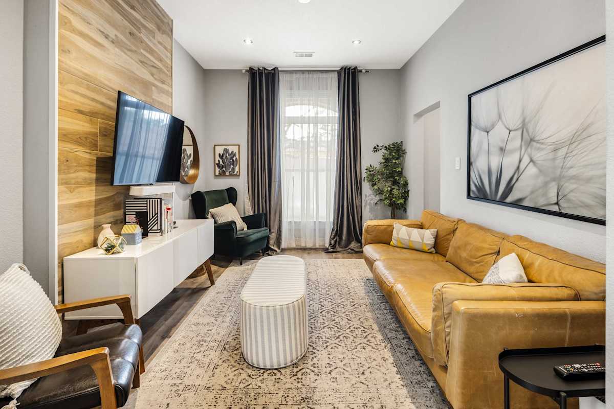 【Living Room】Sink into the leather sofa — the wood-wall TV is angled for game night