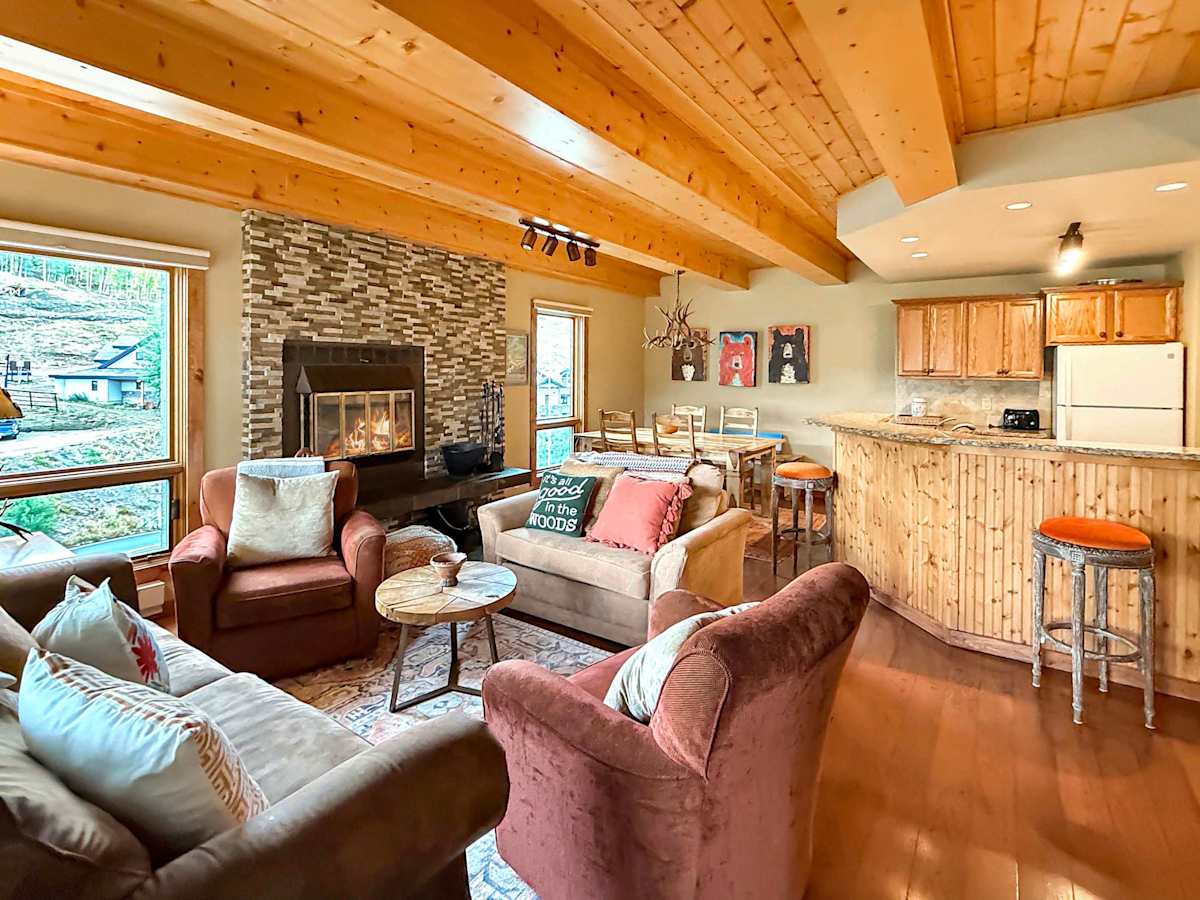 Cozy open living room with wood burning fireplace | Listed with @BookTraverse