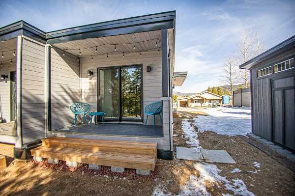 【Private Patio】Back deck with seating — quiet afternoon light, hill trees visible, outdoor space for solo travelers.