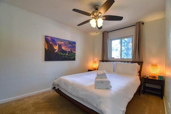 【Second Bedroom】Queen bed, blackout shades, bedside lamps — good for staggered schedules or a partner on a different clock