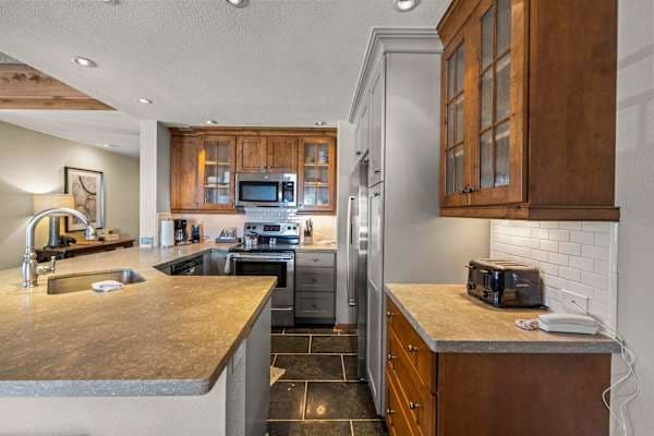 【Kitchen】Renovated cabinets, full-size fridge + range + dishwasher — cook for 6 before lifts open | Listed with @BookTraverse
