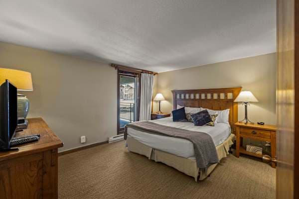 【Bedroom 1 — Primary King】King bed + en-suite bath — quiet end of the condo | Listed with @BookTraverse