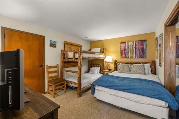 【Bedroom 2 — Queen + Bunks】Queen plus Twin-over-Twin bunks — sleeps 4, the kids' room