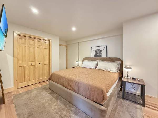 【Bedroom】 Cow art over the bed — closet, queen, TV facing the foot of the bed